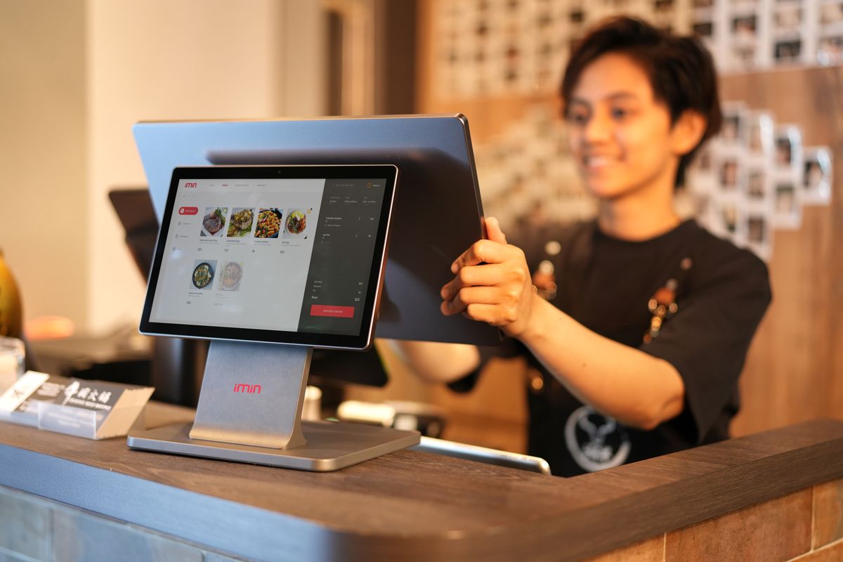 Terminal Smart POS Android com tela sensível ao toque sobre o balcão de atendimento.